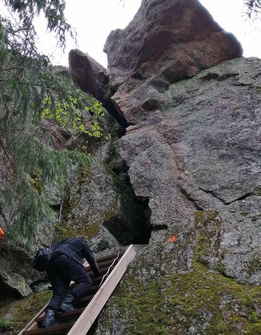 A person climbing up the stairs to a cave.