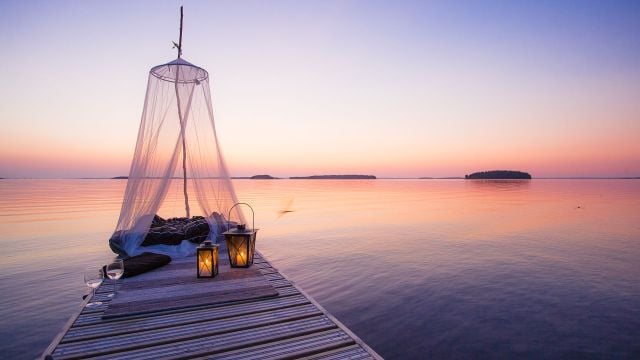 Iltarusko ja laituri, johon on katettu illallinen.